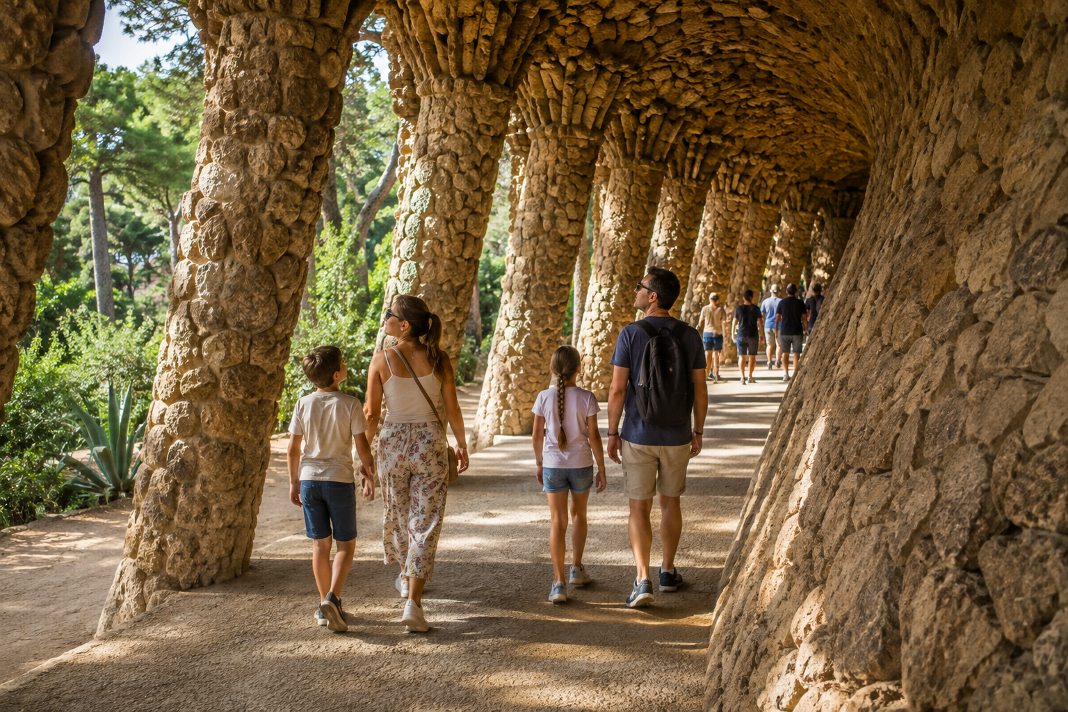 Visiting Park Güell With Kids in Barcelona Family with two children exploring Gaudí’s stone portico at Park Güell in Barcelona