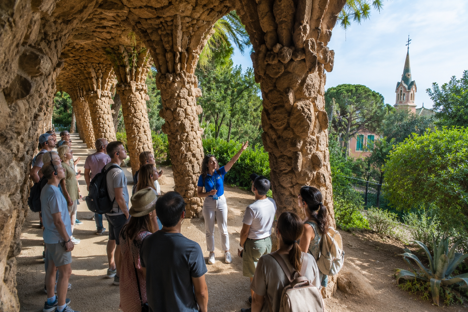 Best Time for a Park Güell Guided Tour in Barcelona Guide leading visitors through the stone portico at Park Güell in Barcelona during a guided tour